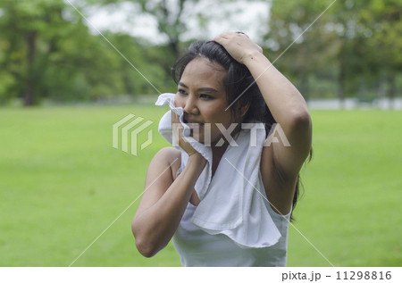 Asian woman wiping sweat with a towel after exercising 11298816
