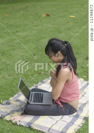 young attractive woman using laptop in the park young attractive woman using laptop in the park 11298872