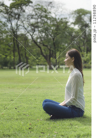 Attractive Healthy Asian Woman meditating in the park 11298890
