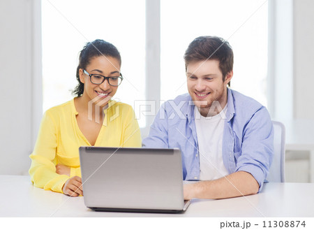 two smiling people with laptop in office two smiling people with laptop in office 11308874