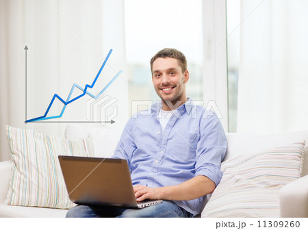 smiling man working with laptop at home 11309260
