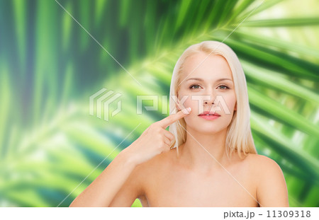 calm young woman pointing at her cheek calm young woman pointing at her cheek 11309318