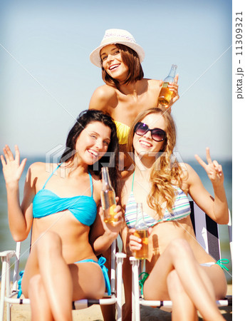 girls with drinks on the beach chairs 11309321