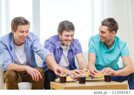 smiling friends with soda and hamburgers at home smiling friends with soda and hamburgers at home 11309387