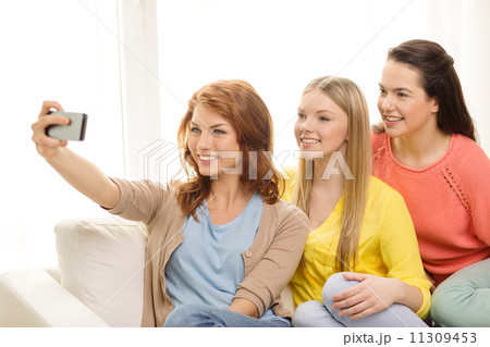 smiling teenage girls with smartphone at home smiling teenage girls with smartphone at home 11309453