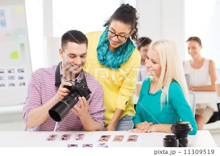 smiling team with photocamera working in office smiling team with photocamera working in office 11309519