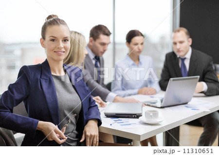 businesswoman with glasses with team on the back businesswoman with glasses with team on the back 11310651
