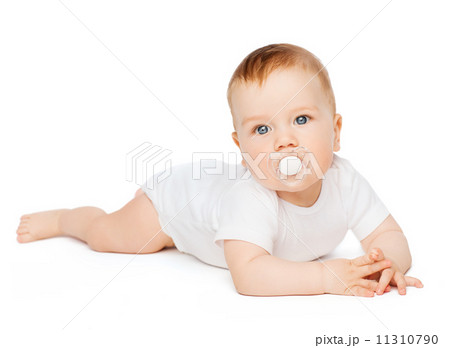 smiling baby lying on floor with dummy in mouth 11310790