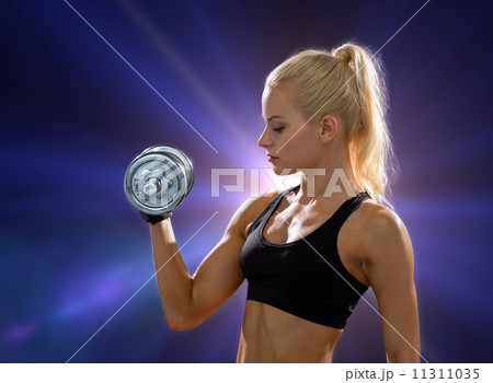 young sporty woman with heavy steel dumbbell 11311035