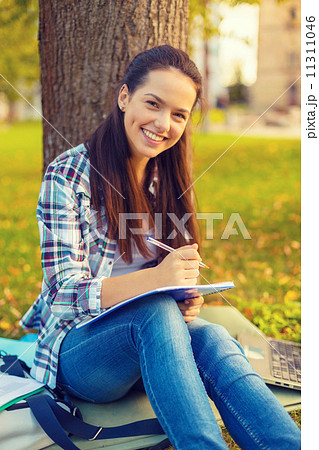 smiling teenager writing in notebook smiling teenager writing in notebook 11311046