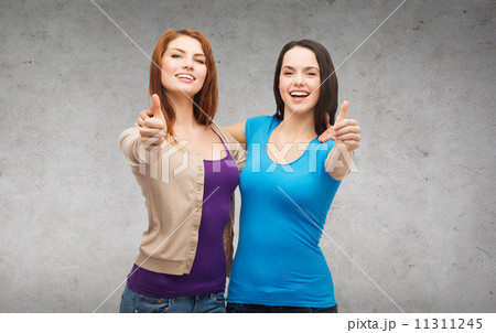 two smiling girls showing thumbs up two smiling girls showing thumbs up 11311245