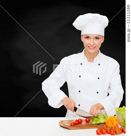 smiling female chef chopping vegetables smiling female chef chopping vegetables 11311266