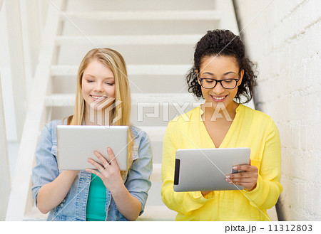 smiling female students with tablet pc computer smiling female students with tablet pc computer 11312803