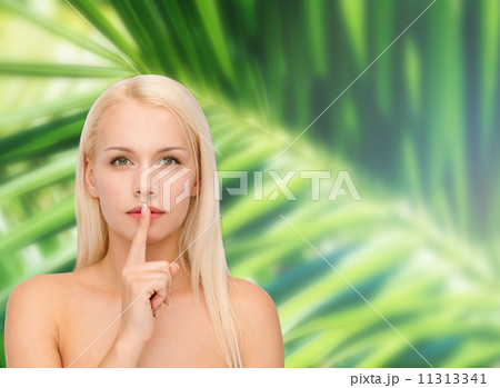 calm young woman with finger on lips 11313341