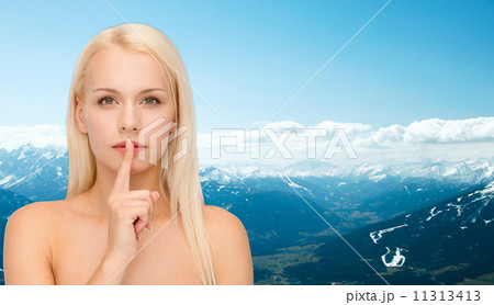 calm young woman with finger on lips 11313413
