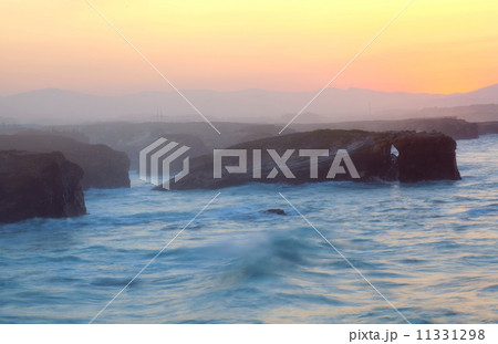 Beautiful sunset and stone arches on Playa de las Catedrales during inflow, Spain Beautiful sunset and stone arches on Playa de las Catedrales during inflow, Spain 11331298