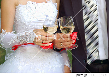 glasses with champagne in the hands of groom and fiancee 11338373