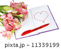 notebook with a pen by flowers and heart 11339199