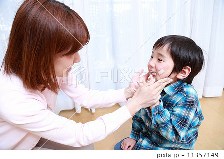 男の子の顔に絆創膏を貼るママの写真素材