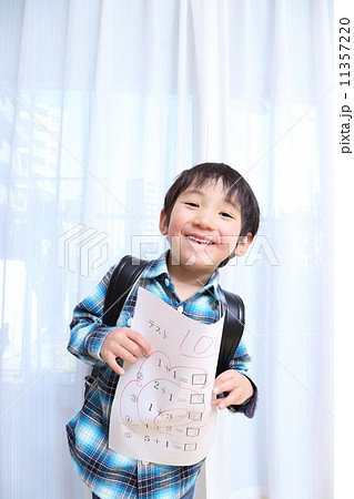 100点満点のテスト用紙を持って笑顔の男の子 11357220