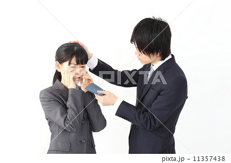 泣く女性社員となぐさめる男性社員の写真素材