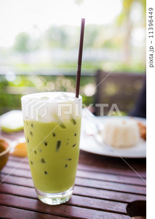 Green tea smoothie on wooden table, natural backdrop 11396449
