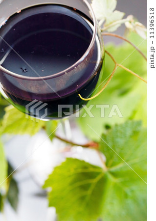 Red wine in glass with grape leaves Red wine in glass with grape leaves 11396518