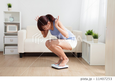Upset woman on weigh scale 11407253