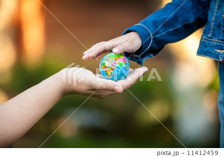 man giving little girl globe on hand man giving little girl globe on hand 11412459