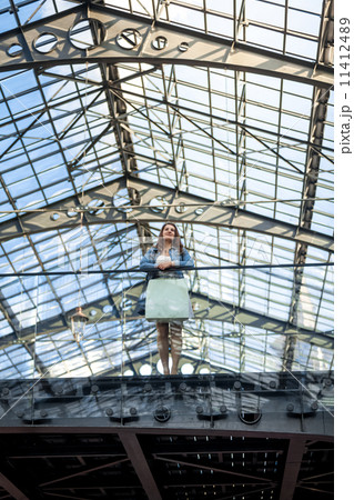 young woman standing on glazed balcony at airport terminal young woman standing on glazed balcony at airport terminal 11412489