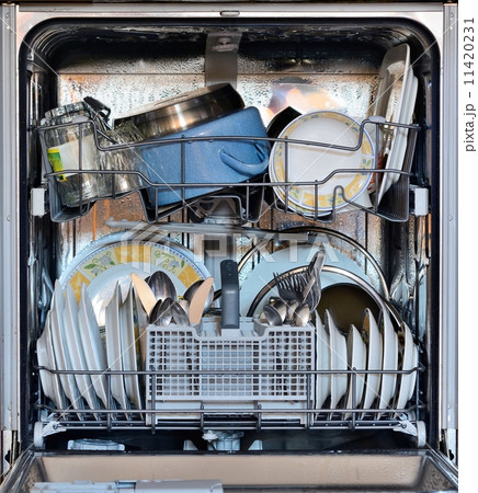 Open the front door of the dishwasher full of clean dishes 11420231