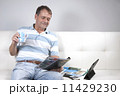 Adult Male Relaxing having a coffee and reading a magazine. 11429230