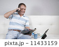 Adult Male Relaxing having a coffee and reading a magazine. 11433159