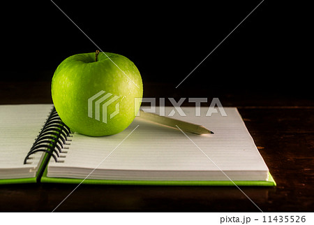 Open book with green apple and pencil Open book with green apple and pencil 11435526