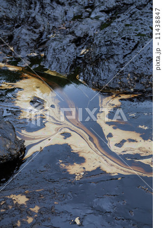 crude oil spill on the stone at the beach crude oil spill on the stone at the beach 11438847