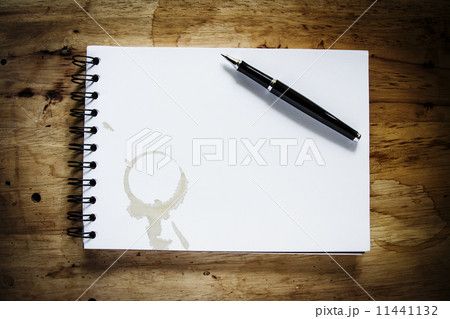 coffee stain on spiral book with pen on vintage wood table backg coffee stain on spiral book with pen on vintage wood table backg 11441132