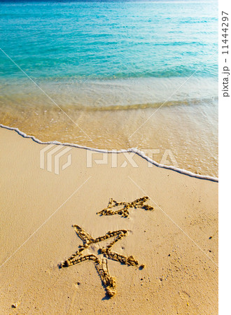Drawing on sand on a theme of rest - a starfish and a small fish Drawing on sand on a theme of rest - a starfish and a small fish 11444297