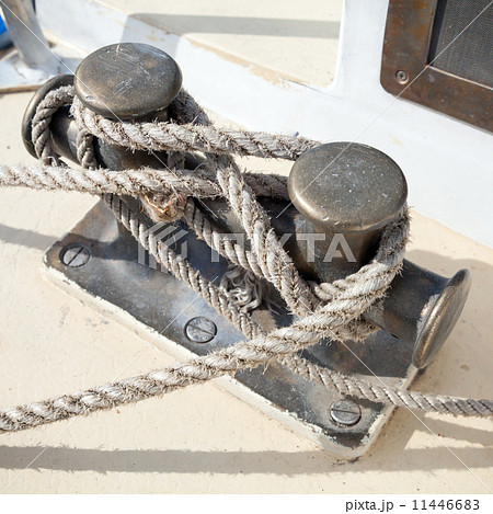 Dark bollard with rope knot on yacht deck Dark bollard with rope knot on yacht deck 11446683