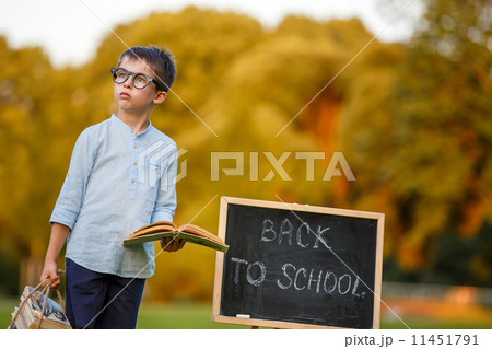 Cute little schoolboy reading book 11451791