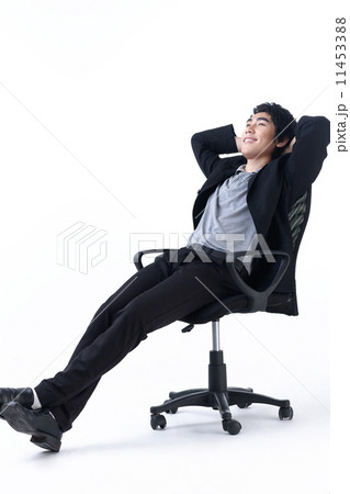 Relaxed young business man sitting on the chair Relaxed young business man sitting on the chair 11453388