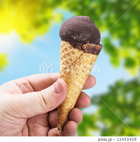 hand holding ice cream with chocolate on a background of nature hand holding ice cream with chocolate on a background of nature 11453429