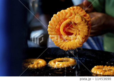 Cropped image of vendor preparing jalebis at stall 11453690