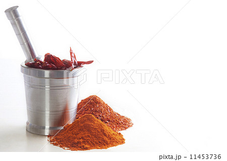 Chili powder with chili peppers in mortar and pestle over white background 11453736