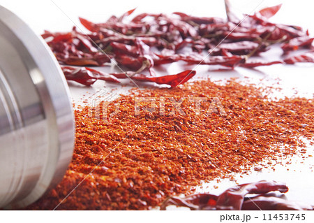 Chili powder and red chili peppers spread over white background 11453745