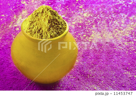 Close-up of pot filled with yellow Holi color powder 11453747