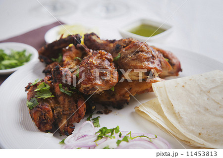 Fried chicken with onions in plate at table 11453813