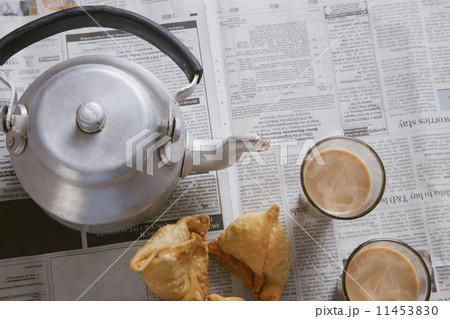 Directly above shot of tea glasses, samosas and kettle on table 11453830