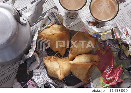 Directly above shot of fresh samosas, tea and kettle on table 11453899