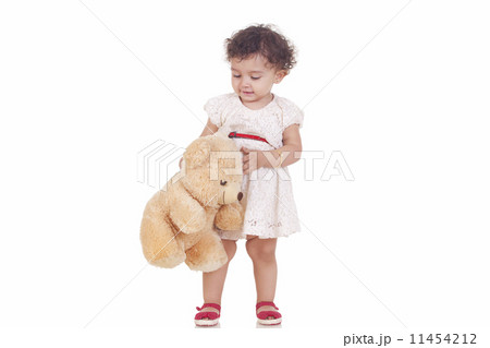 Full length of cute girl playing with stuffed toy against white background Full length of cute girl playing with stuffed toy against white background 11454212