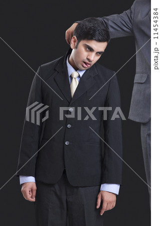 Cropped image of businessmen holding colleague by collar against black background 11454384